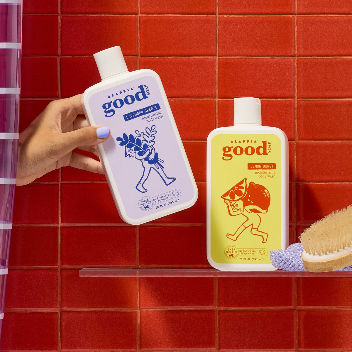 A hand holding Lavender Breeze body wash beside Lemon Burst on a shower shelf in front of red tile.